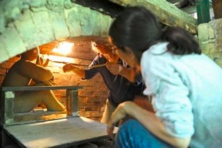 Naoko Ojio and Brown begin loading the kiln