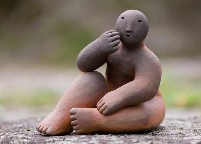 sitter with hand over mouth